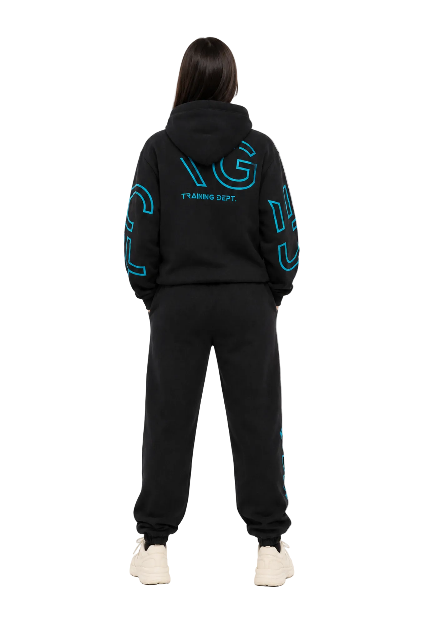 A model viewed from the back wearing a black hoodie and sweatpants set with bright blue graphic lettering that reads 'TURNING OFF.' on the back and sleeves, paired with off-white sneakers, against a plain white studio background.