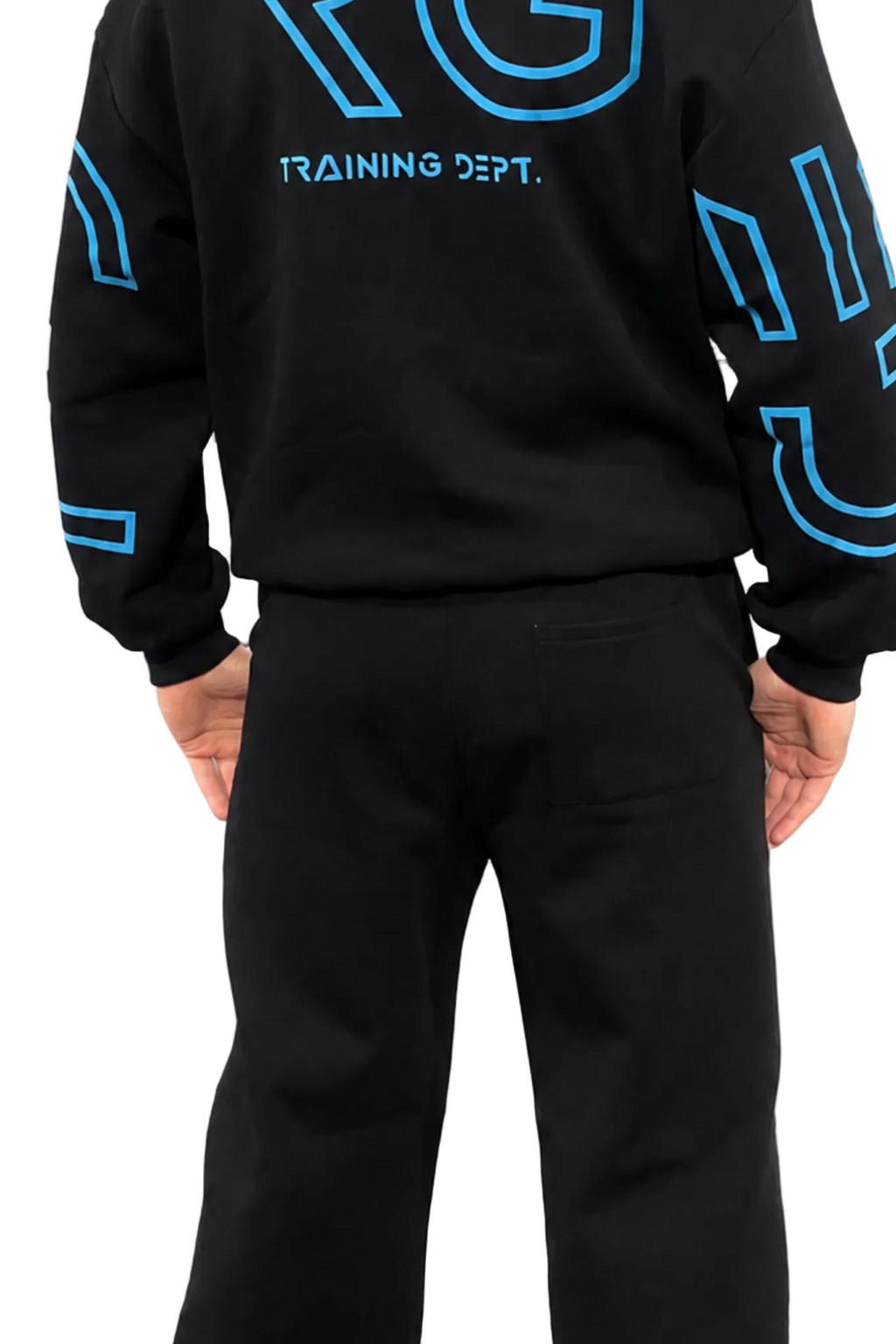 A person shown from the back wearing a black sweatshirt with bright blue outlined graphics and the words 'TRAINING DEPT.' across the upper back, paired with black pants, on a plain white background.