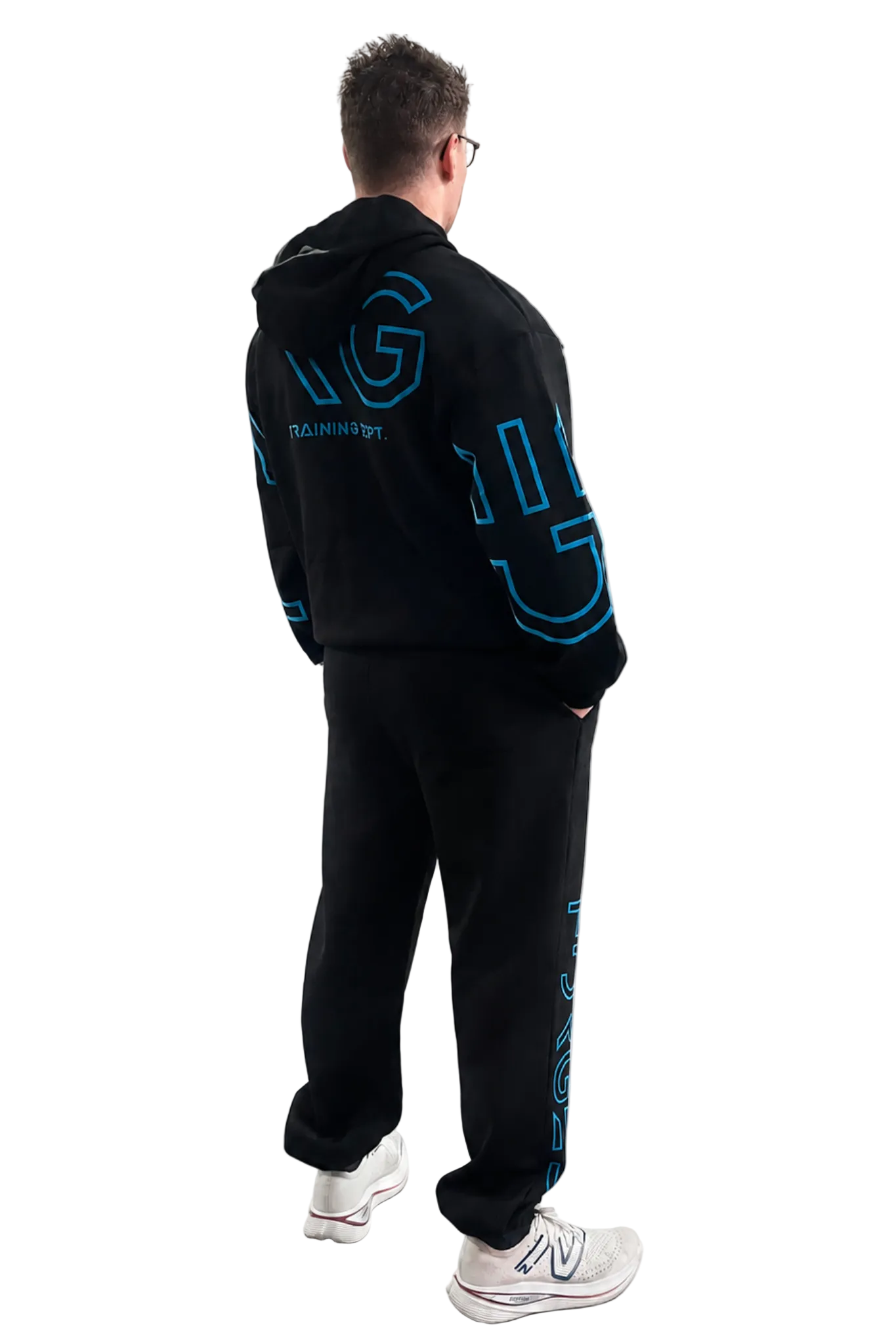 A man wearing a black hooded sweatshirt and matching sweatpants with bright blue graphic lettering, shown from the back against a light gray studio background.