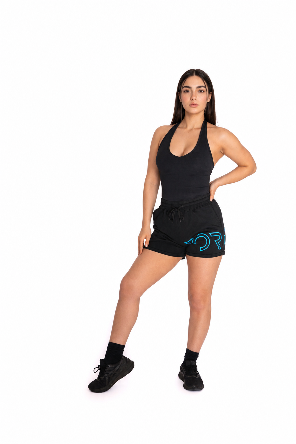A woman modeling a black athletic tank top and matching black shorts with a bright blue graphic logo on the side, posed against a solid white background.