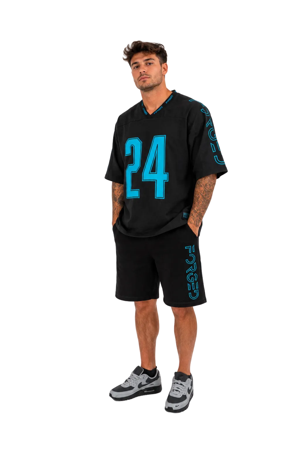 A man modeling a black athletic jersey and matching shorts set with bright turquoise accents, including the number 24 on the front and vertical lettering down the sleeves and shorts, against a plain white studio background.