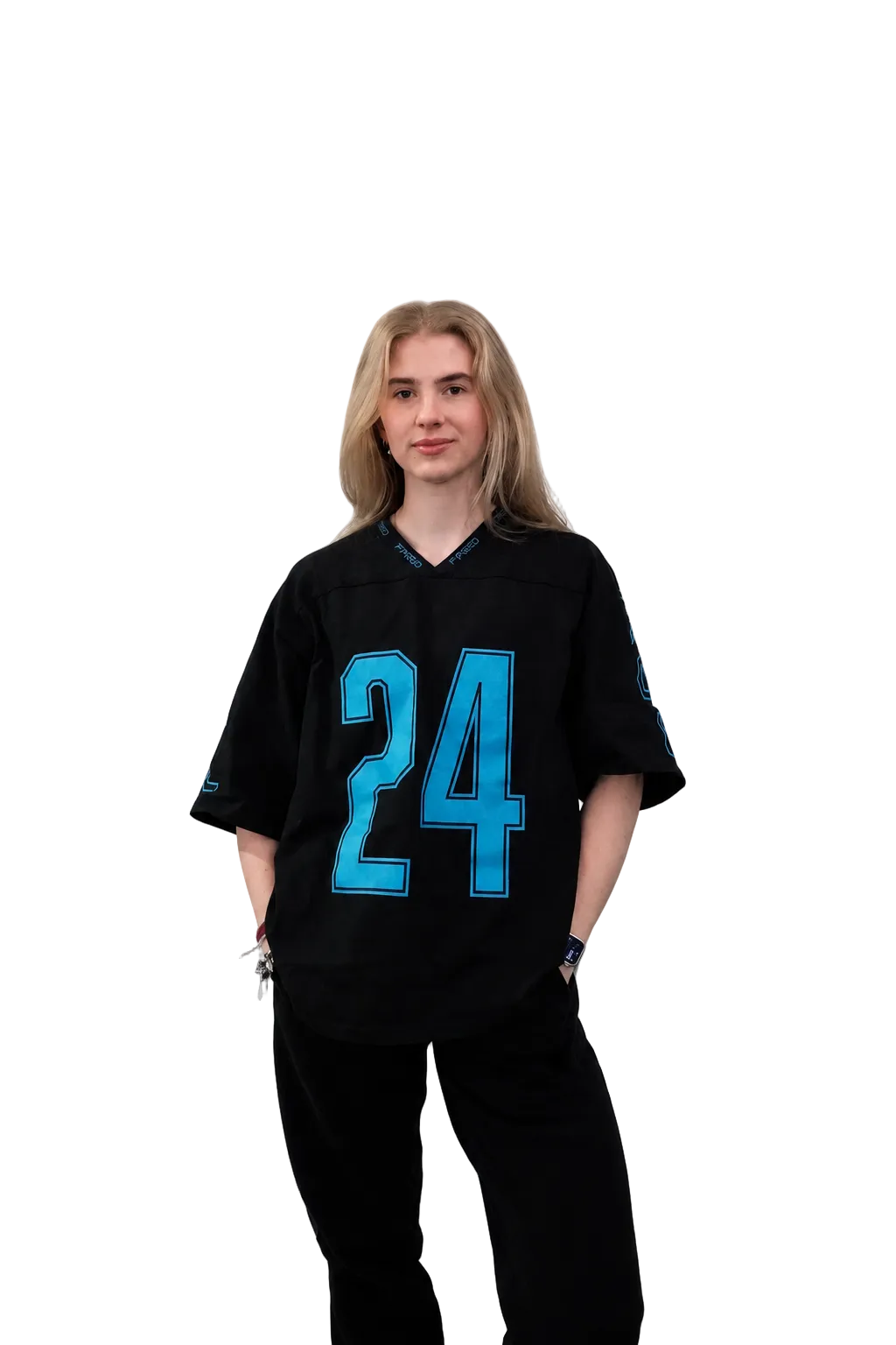 A young woman with blonde hair stands against a light gray studio background wearing a black short-sleeve sports jersey with the number 24 in bright blue outlined numerals on the front, paired with black pants.