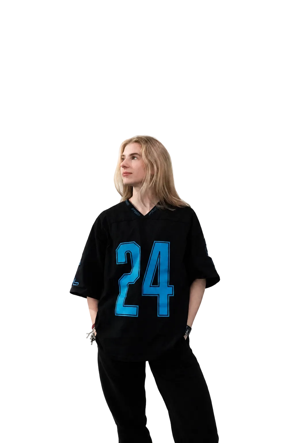 A woman wearing a black football-style jersey with a large blue number 24 on the front, paired with black pants, standing against a plain white studio background.